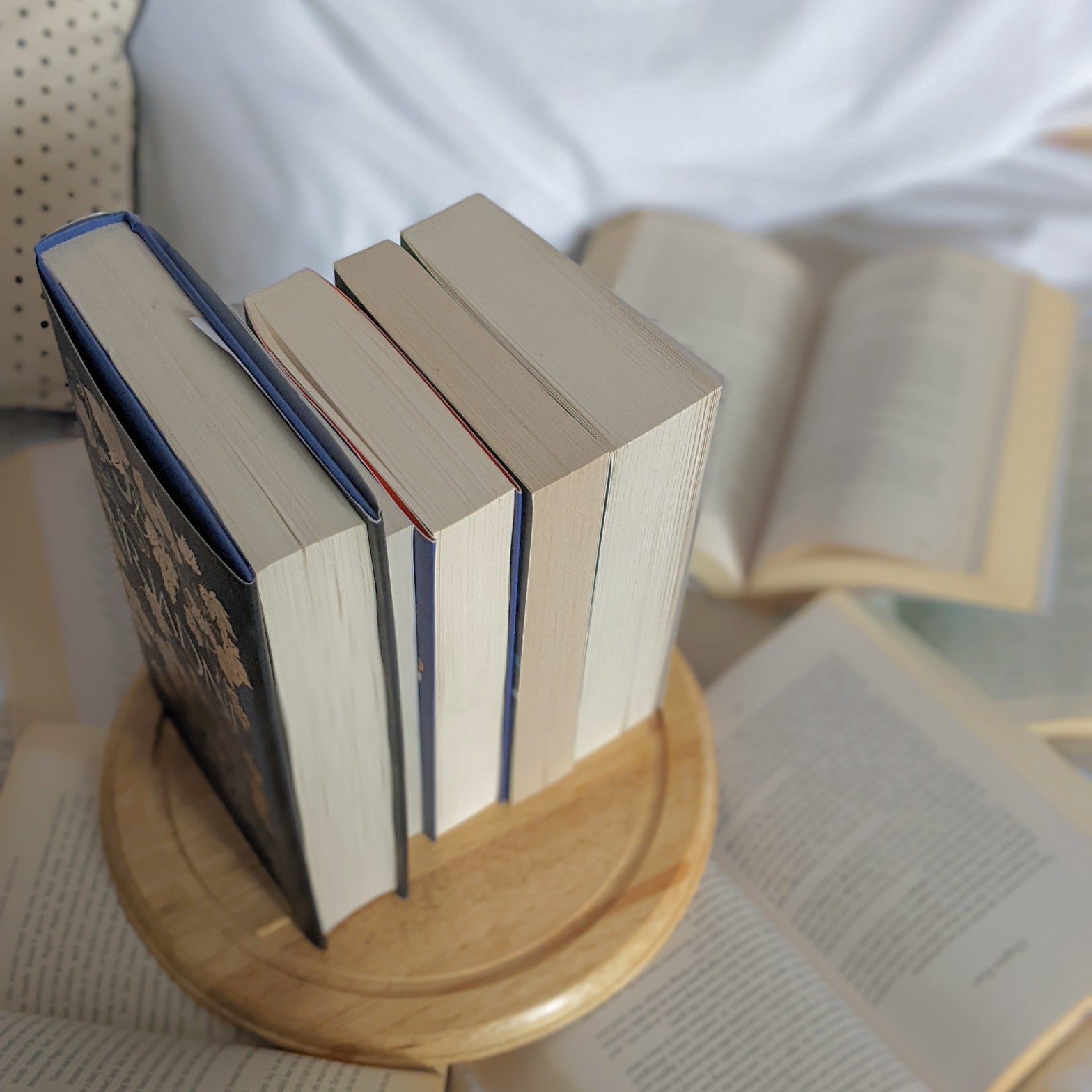 five books on a wooden plate for a post on how to pick your next read